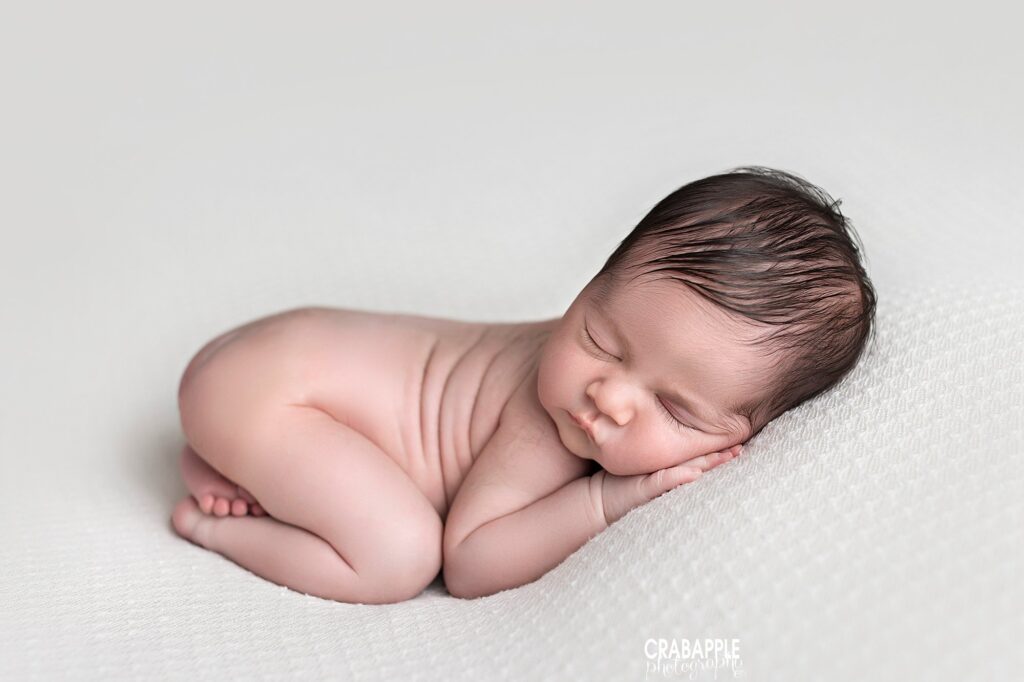 Newborn baby expertly posed on blanket during photo session with Boston newborn photographer