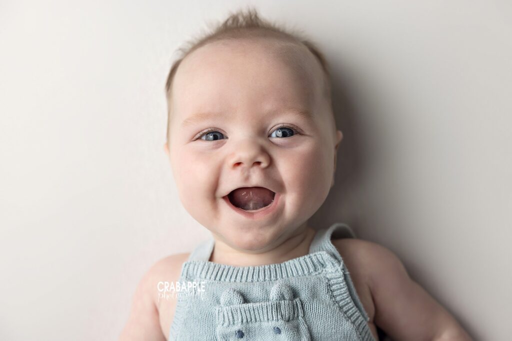 Professional baby portrait of 3 month old baby with huge grin