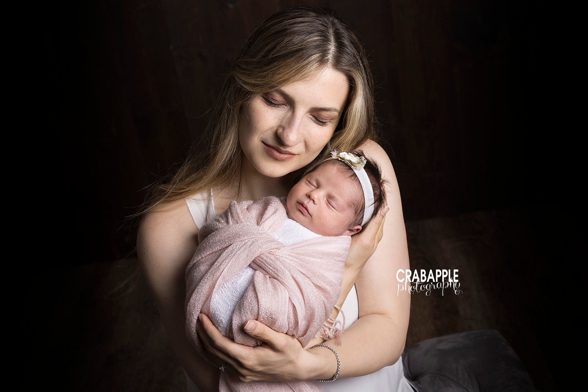 Mom lovingly holding newborn baby during session with experienced newborn photographer near Boston, MA