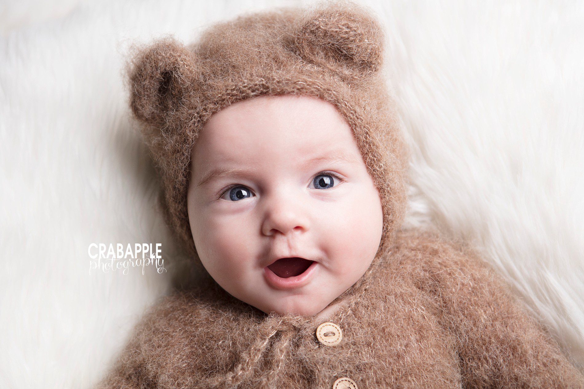 smiling 3 month old baby looking at camera during photo session
