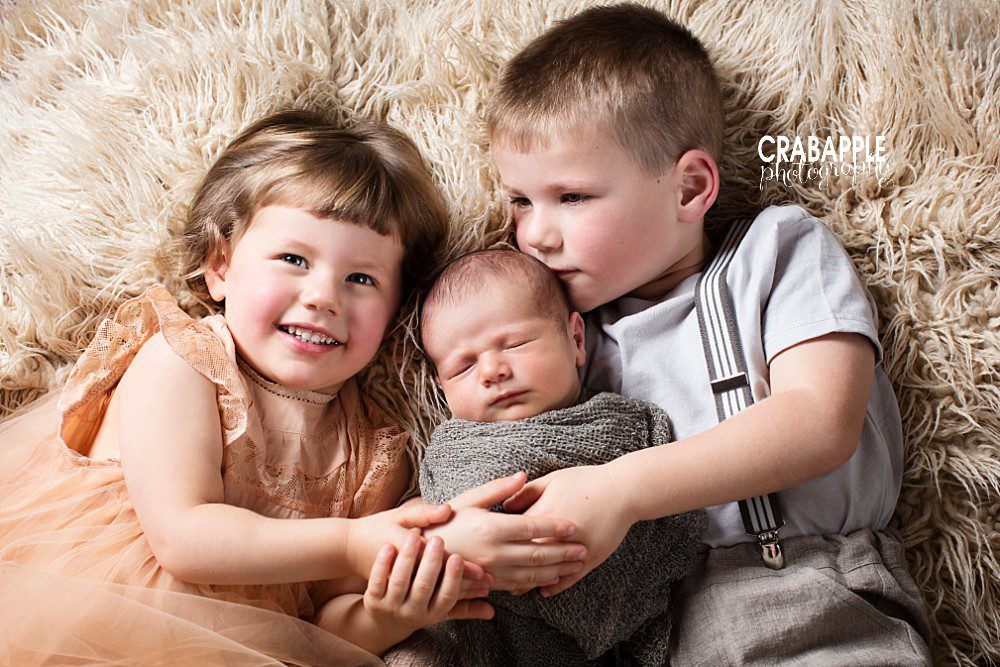 Siblings learning to love their newborn baby with help of postpartum doula