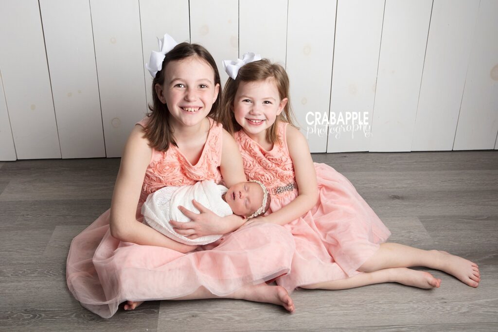 sister photos with newborn