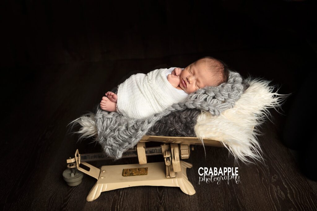 Newborn baby boy photo using a vintage food scale as a prop.