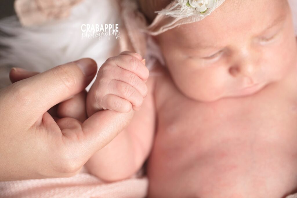 newborn holding parent's finger photo