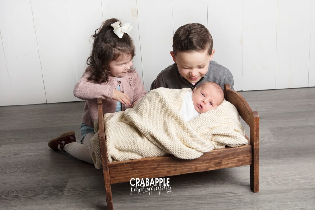 three siblings photo with newborn
