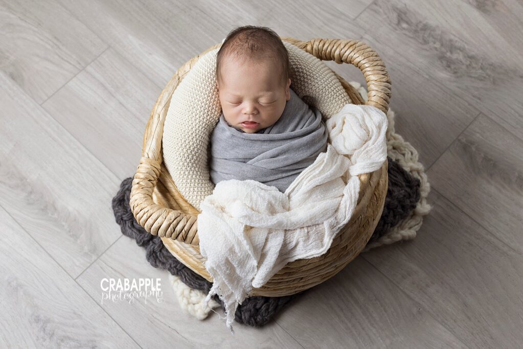 Swaddled and sleeping newborn photos using basket prop.