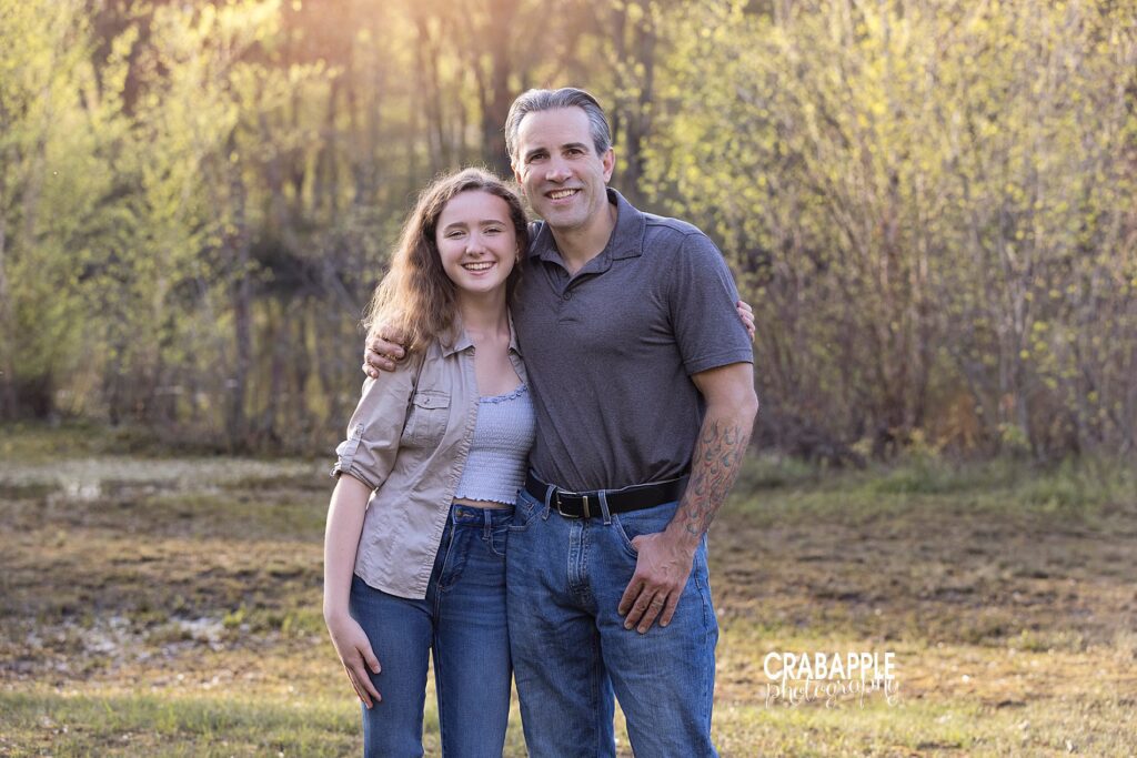 Family photos of laughing father and teenage daughter, standing with their arms around each other outside, smiling at the camera.