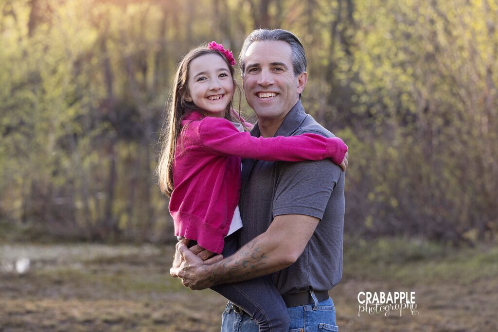 Father and daughter photos of a father holding his 8 year old daughter, they are smiling at the camera.