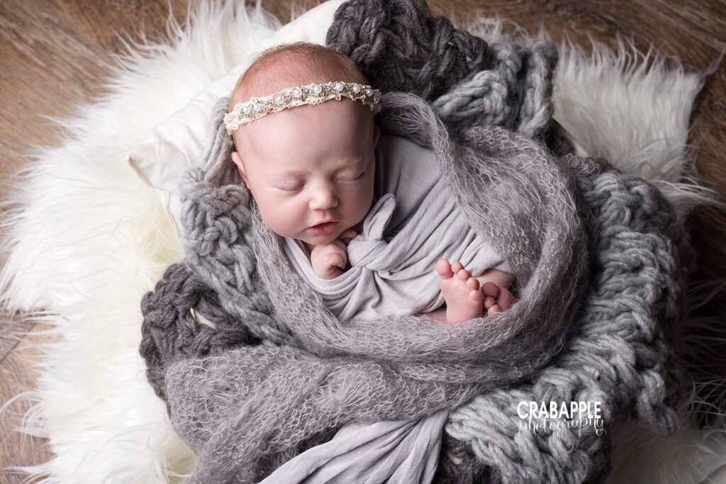 Neutral newborn photo ideas for baby girls using white furs, gray blankets, and dainty pearl headbands.