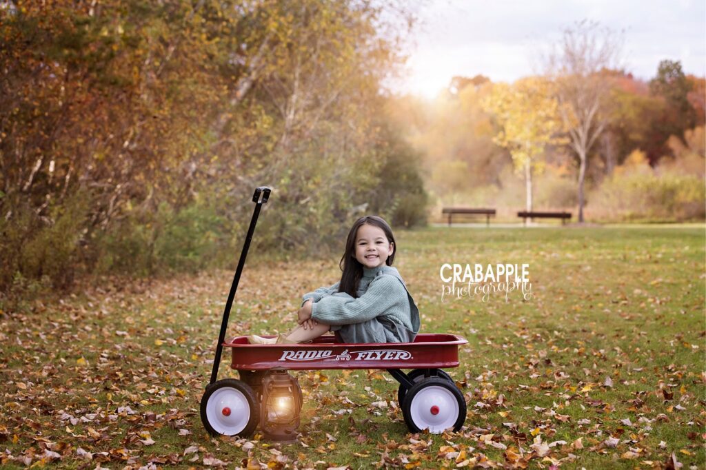 Child photography ideas for outside during fall using a red Radio Flyer wagon.