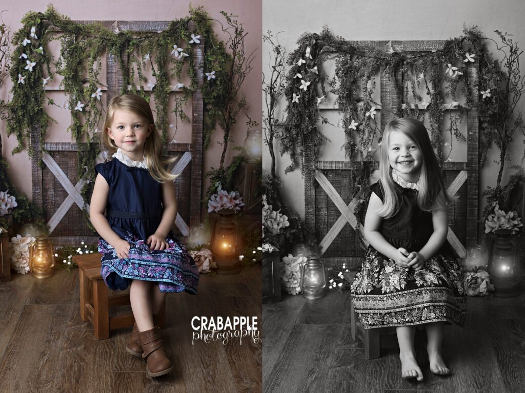 Two portraits of a young girl in an embellished navy blue dress sitting on a wooden stool. In both she is sitting in front of a boho springtime set design with barn doors in flowers. One portrait is in black and white.