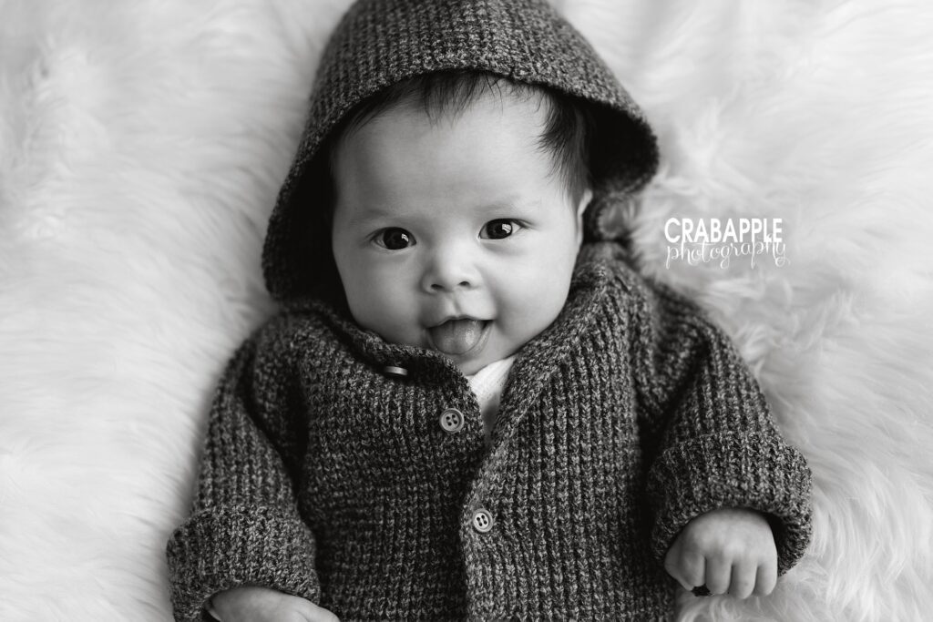 Black and white three month portraits of smiling baby girl wearing a knit sweater.
