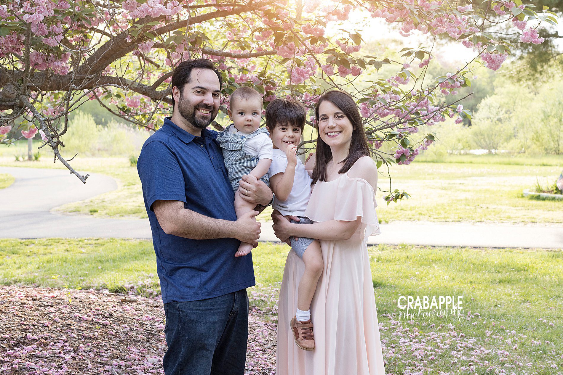 Outdoor springtime family portraits with blooms and blossoming trees.