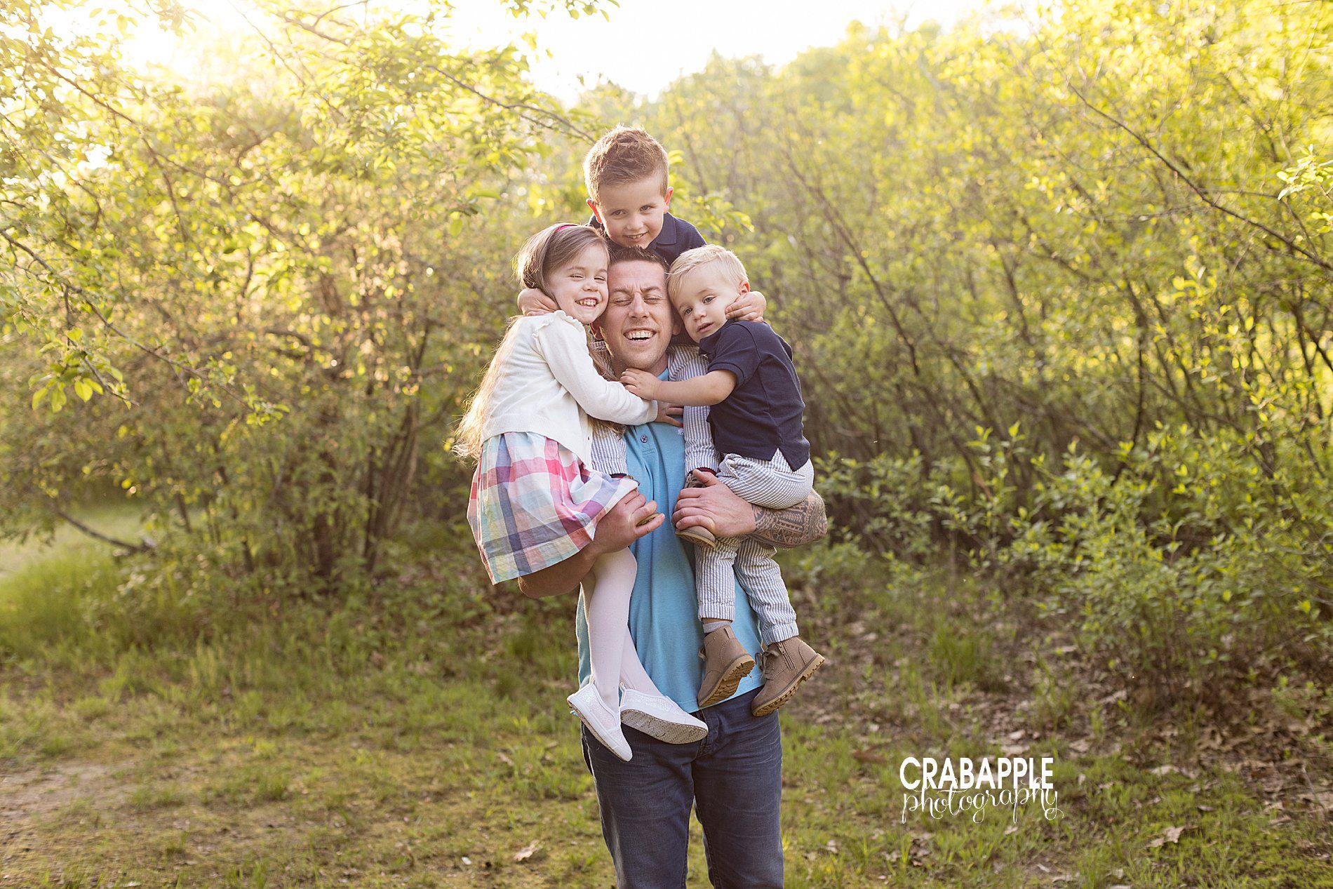 Sweet and creative family portrait posing ideas with dad holding all of his kids.