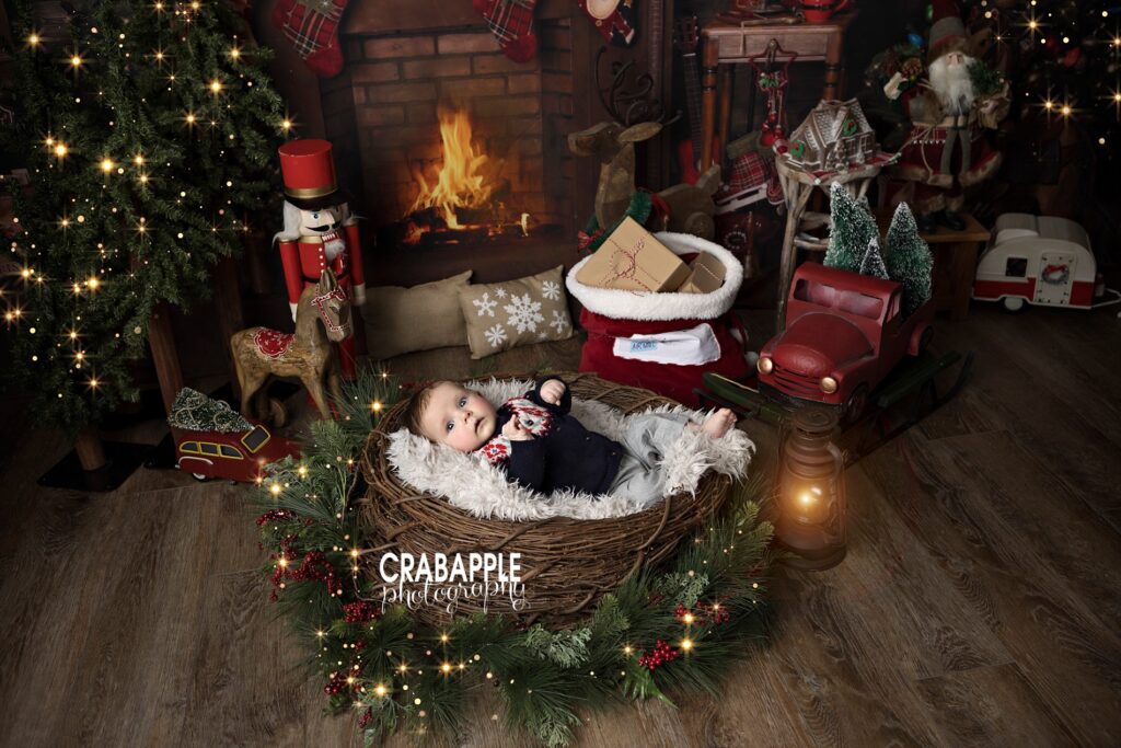Christmas photo ideas for babies using wreath, faux trees, and antique style nutcracker.