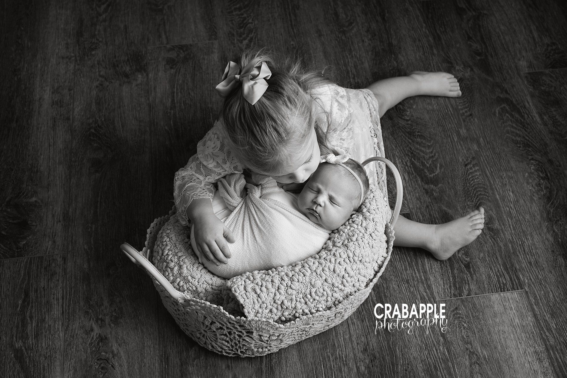 Black and white sister portrait with toddler big sister and newborn baby sister.