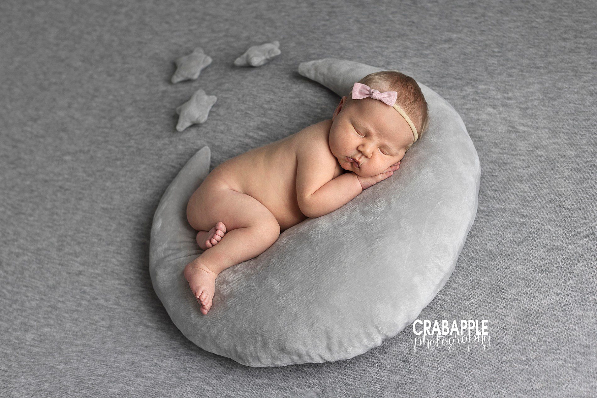 Newborn photo using a crescent moon shaped pillow and small star pillows.