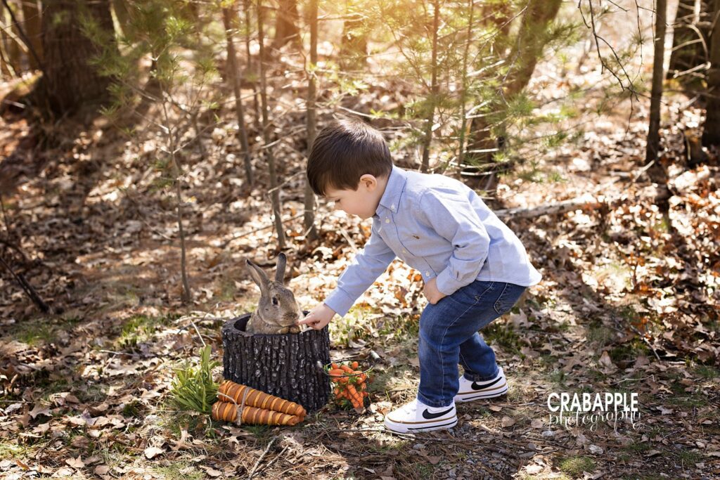 Whimsical child portrait ideas for Easter. Featuring a young boy and a live bunny rabbit sitting in a hollow faux tree stump.