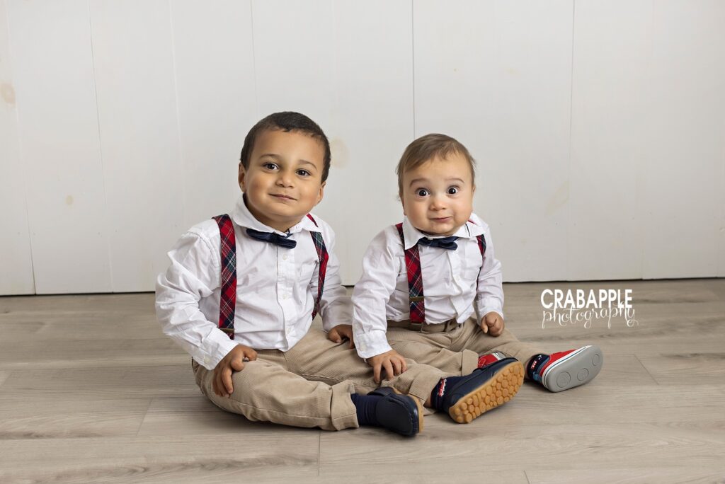 Sibling photos of brothers aged 4 and 1 wearing white button downs, suspenders and bowties.