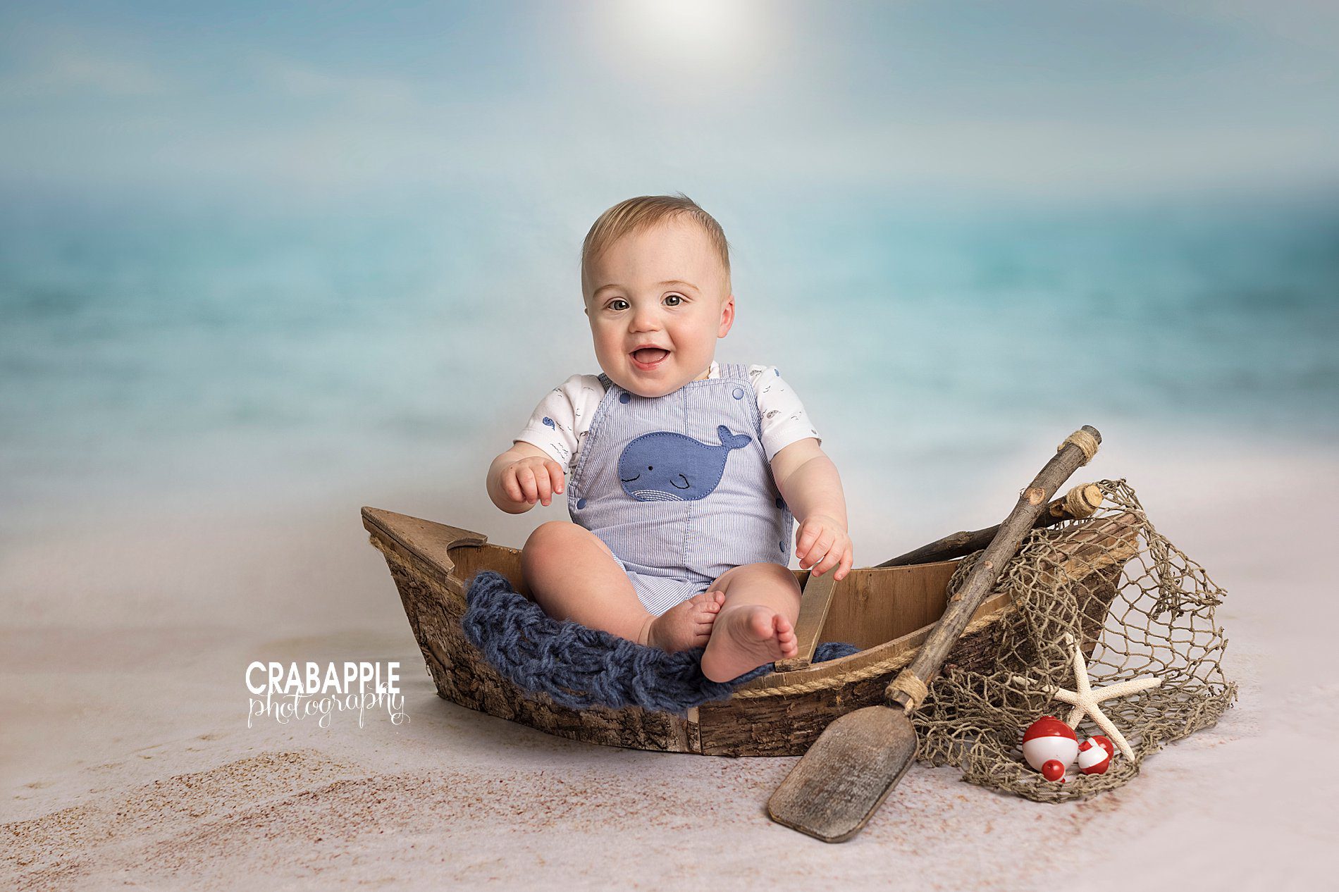 nautical summer baby photos with wooden canoe and seashells