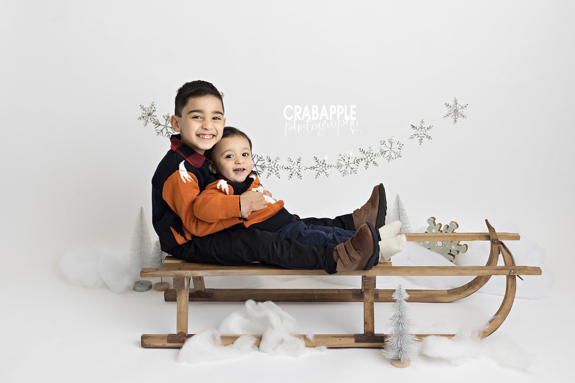 Winter child and baby portrait ideas with stylized set and vintage wooden sleigh