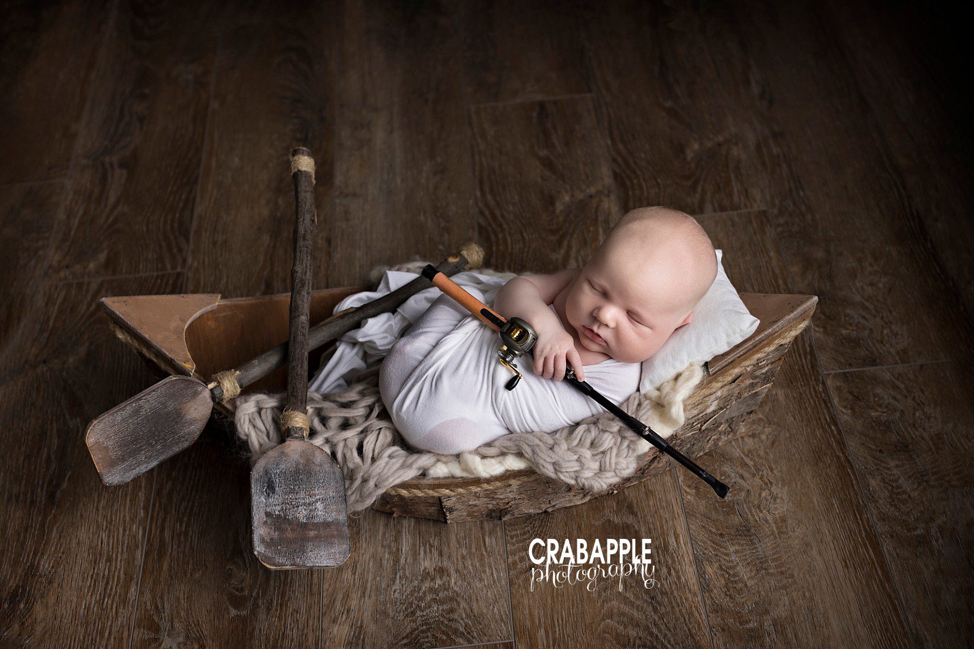 Fishing themed newborn photo with boat and fishing rod props