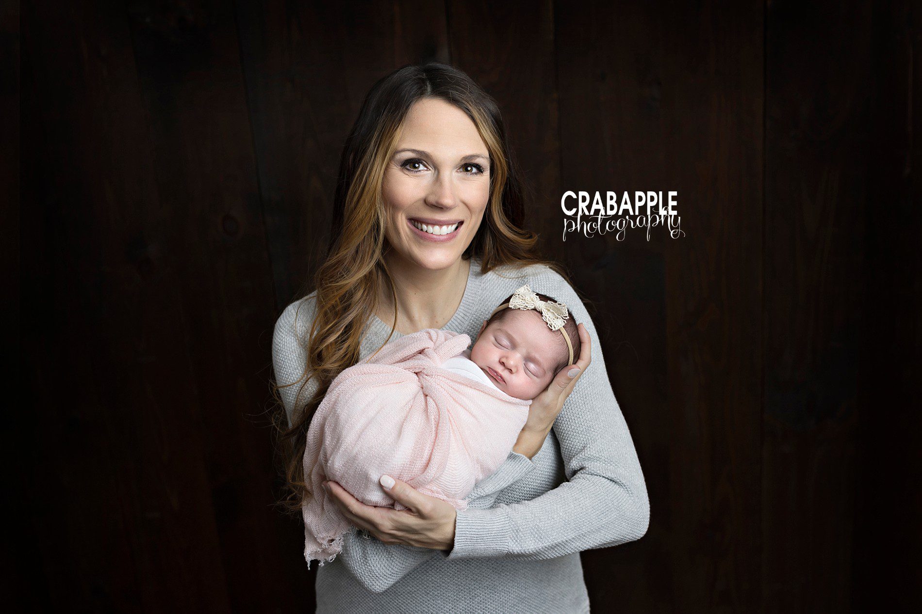 Mother and baby poses for newborn portraits