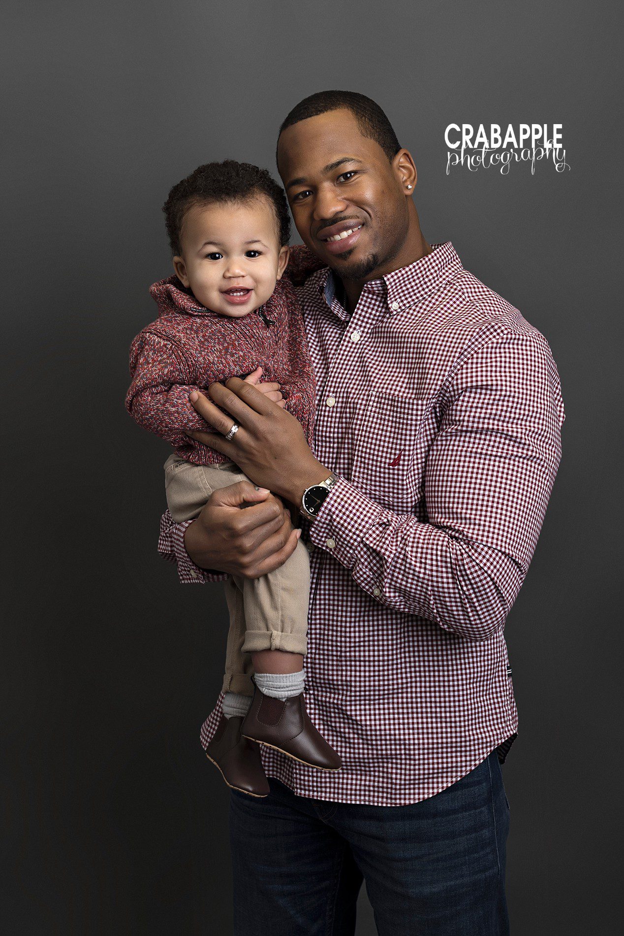 Father and son poses with one year old baby boy