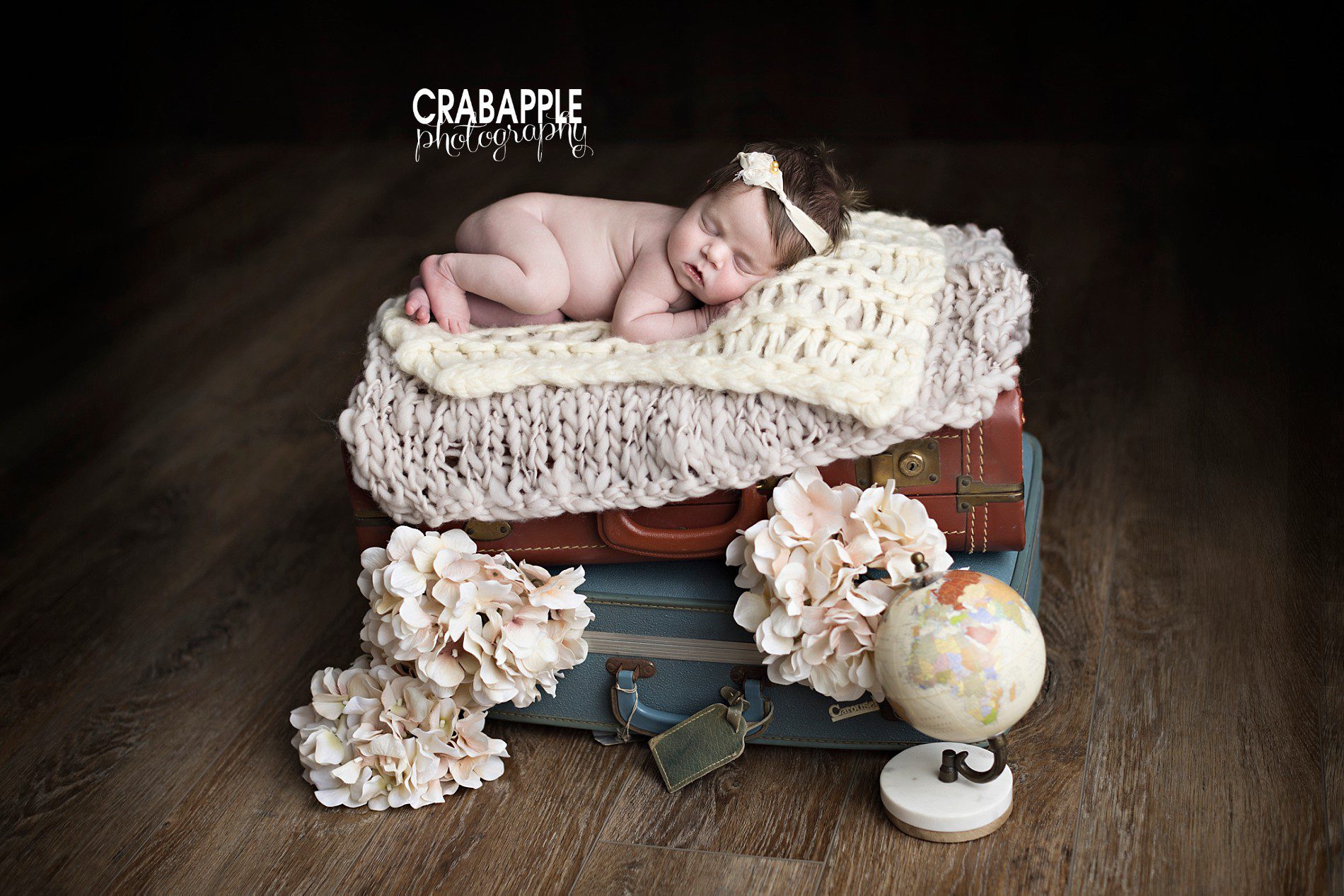 travel themed newborn photos for girls using vintage suitcases, luggage, globe, and flowers
