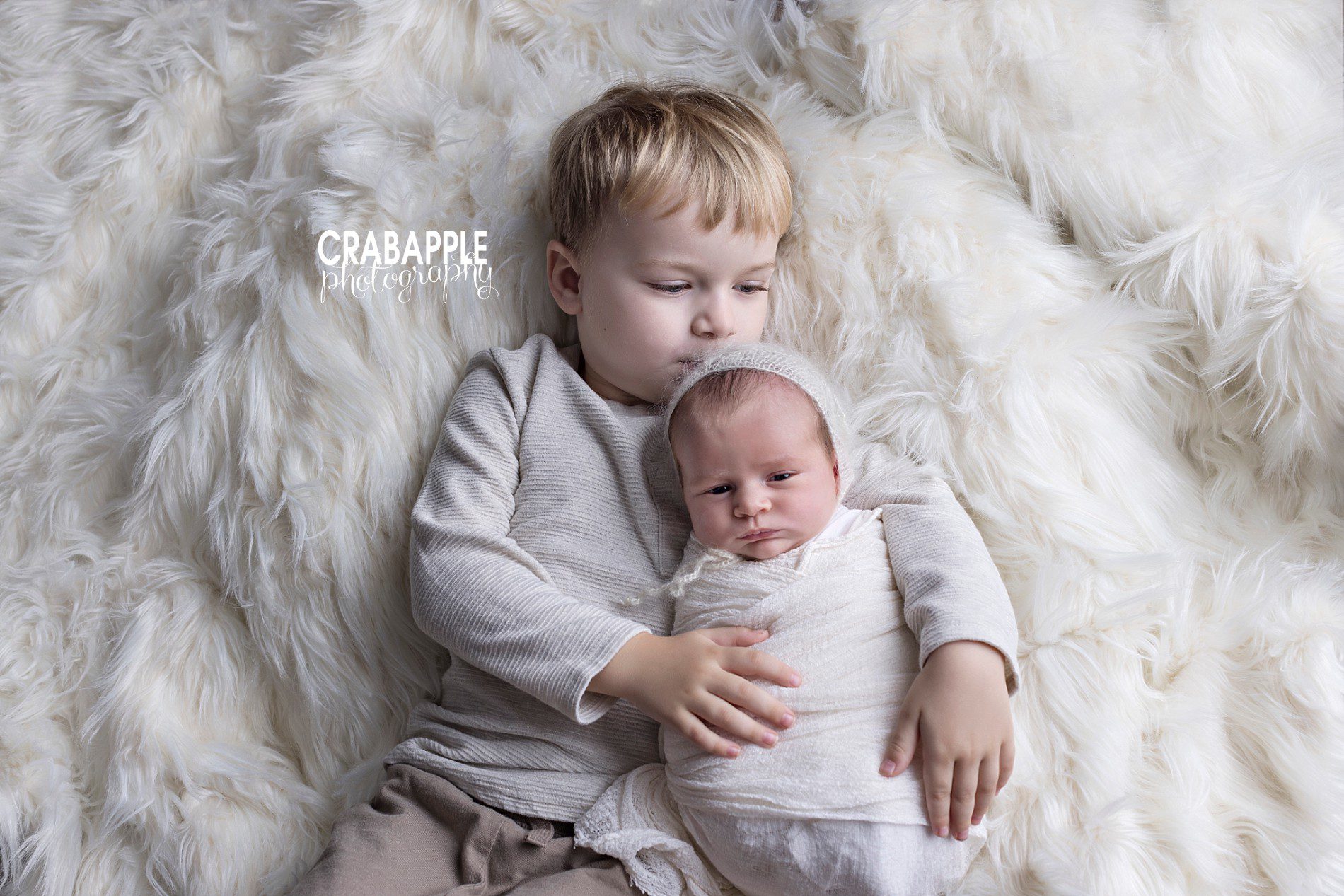poses for newborn photos with toddler sibling
