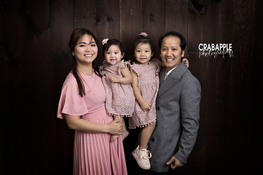 Family of four in coordinating outfits smiles for the camera during Quincy MA birthday session