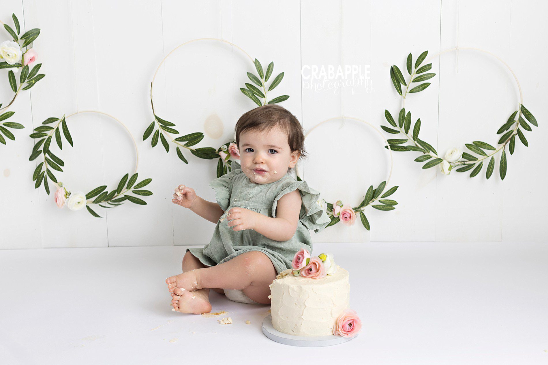 cake smash set design with faux flowers and greenery