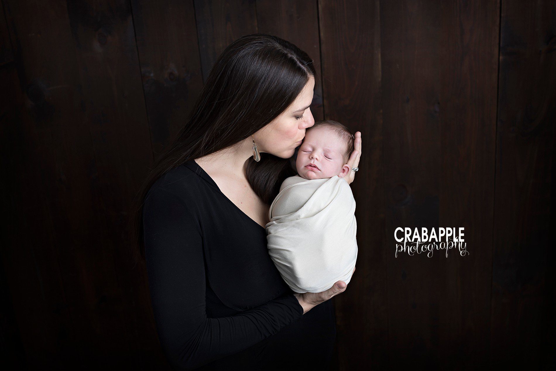mom kissing newborn portrait