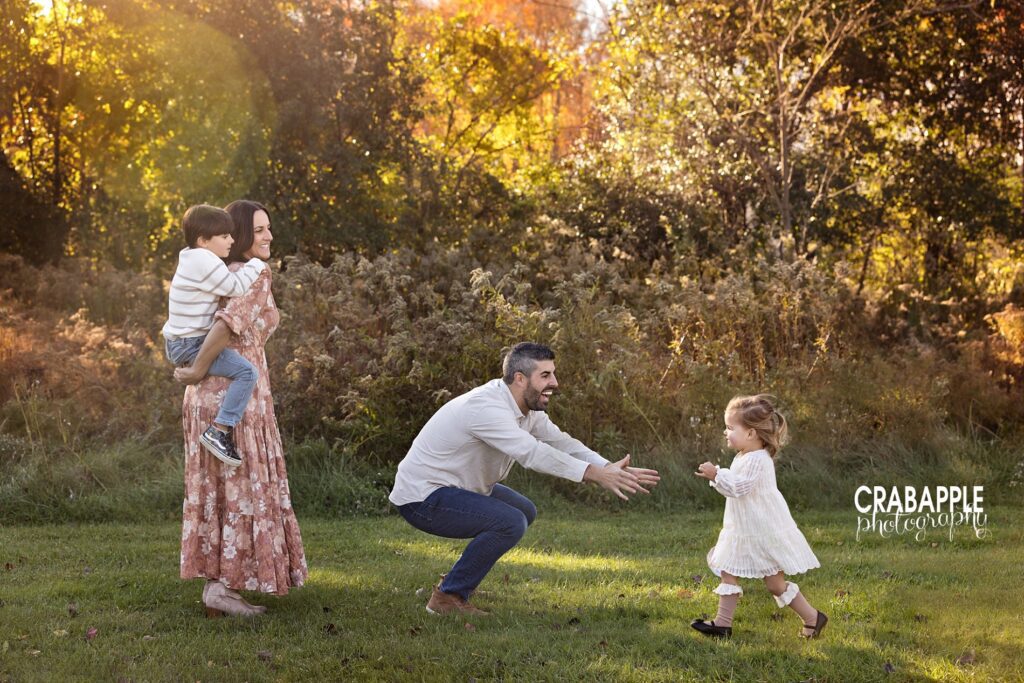 Daughter runs into dad's arms while mom gives son a piggy back ride