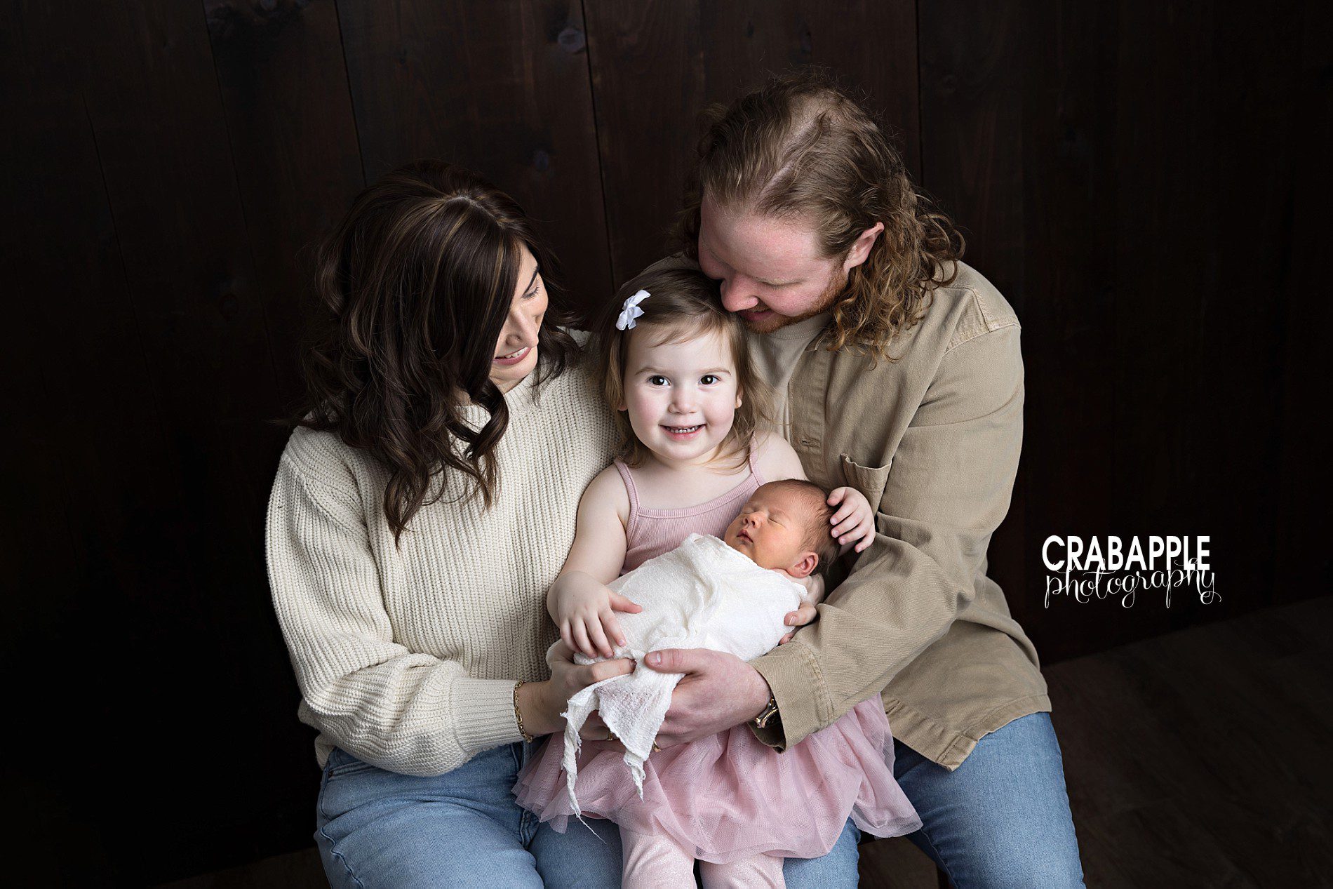 poses for newborn family photos with toddler sibling