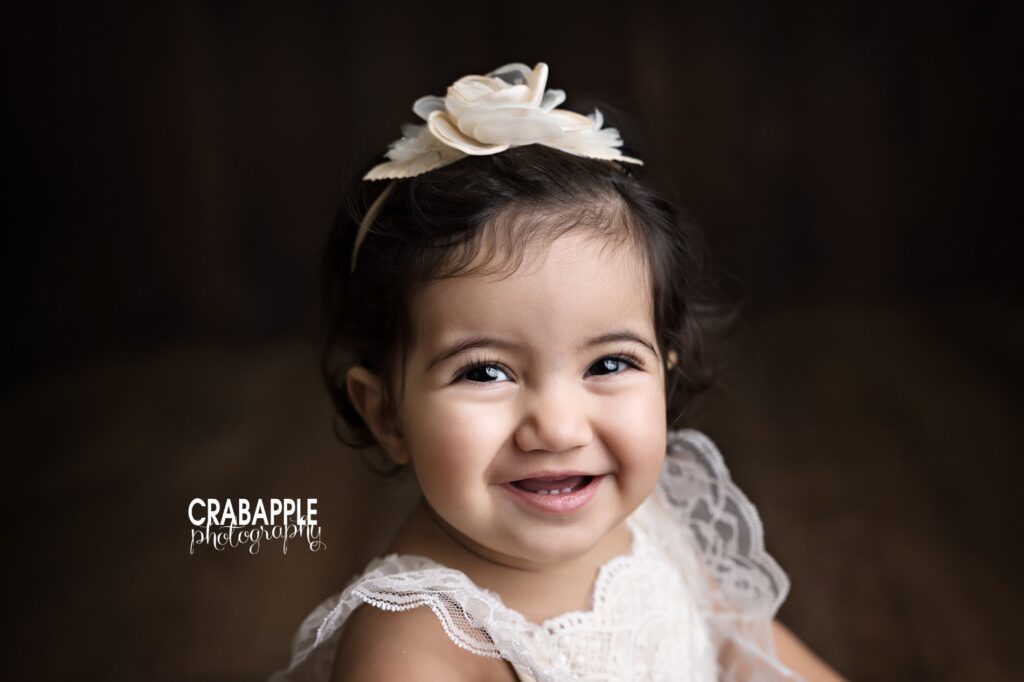 Close up portrait of a smiling 1 year old girl during her Quincy MA cake smash session
