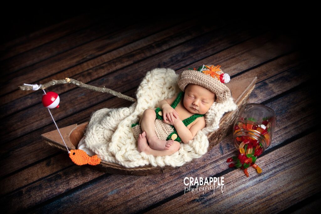 Newborn baby in a sweet fisherman portrait set up complete with gummy worms
