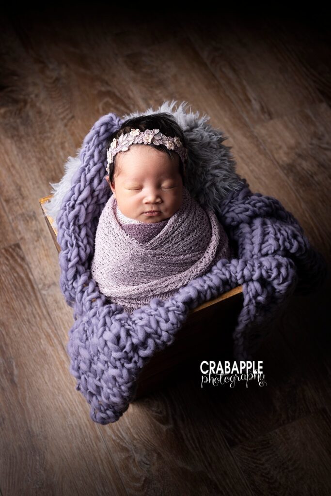 Newborn baby girl wrapped in lavender with floral headband, creative Boston newborn photo session
