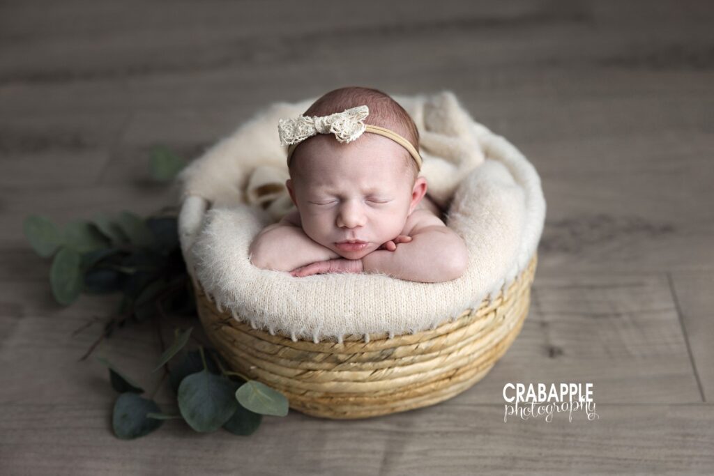  Baby girl resting in basket with headband and greenery – Boston newborn photo session
