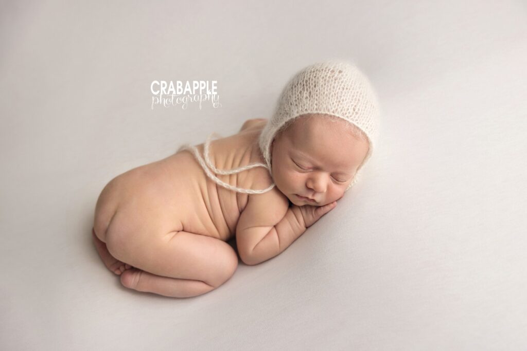 Minimalist newborn portrait in beige bonnet and neutral tones – Massachusetts baby photographer
