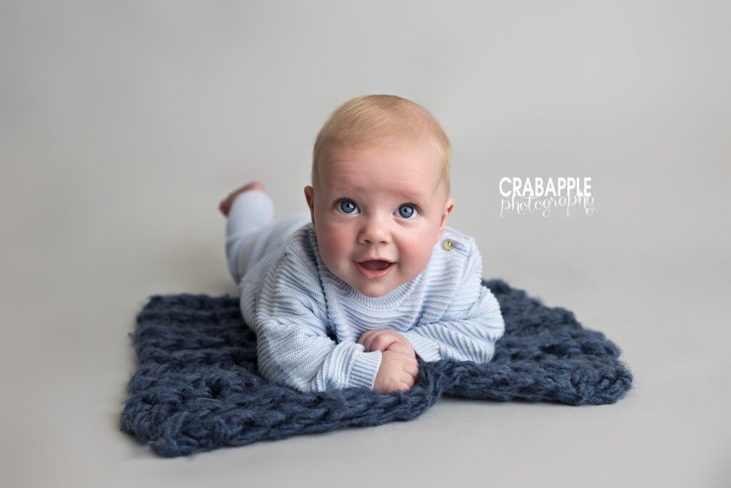 sweet tummy time photo of baby boy wearing blue, on a blue blanket