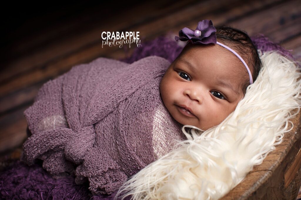 Close-up of baby girl in purple wrap with headband 

