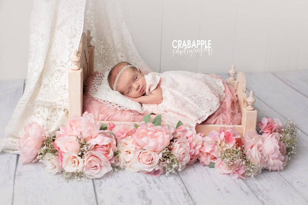 Baby girl in floral setup with lace backdrop 

