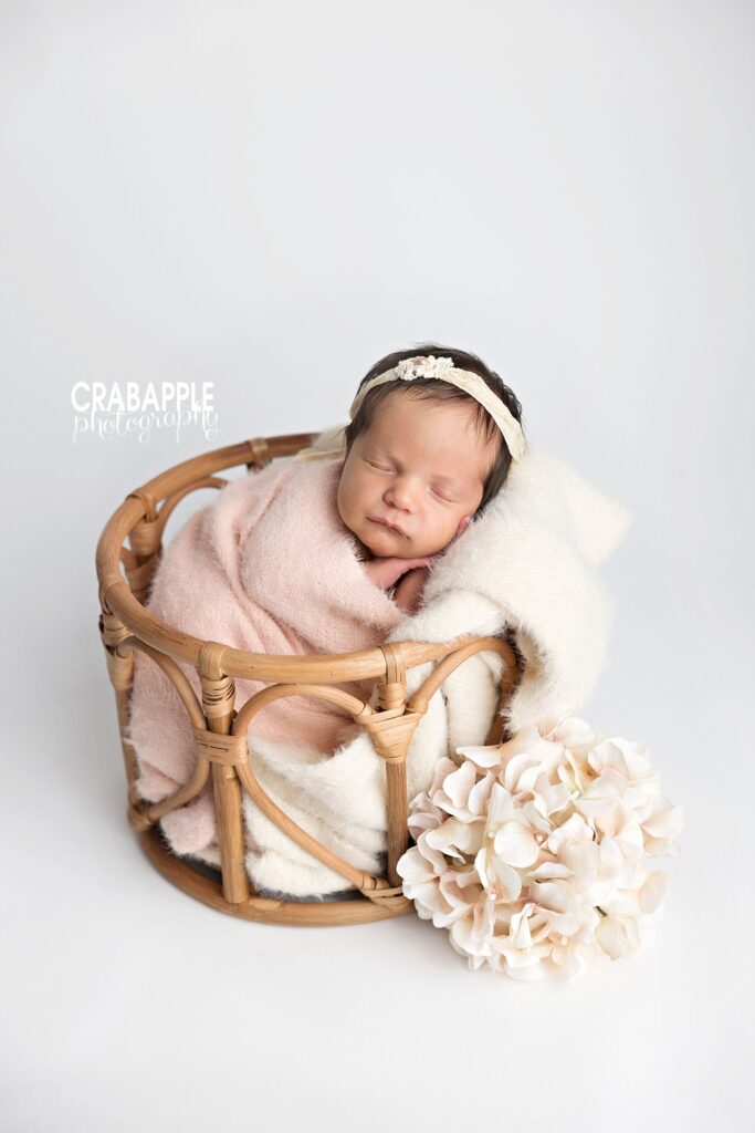 beautifully posed newborn beautifully posed newborn in boho chic wooden basket with soft floral touches