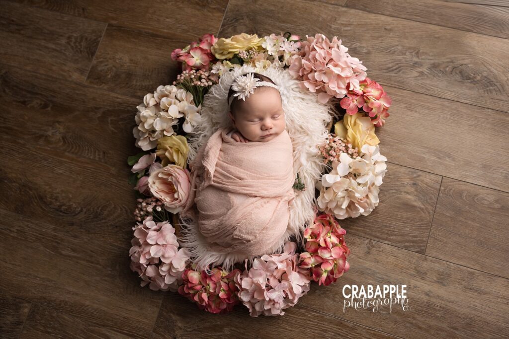 Floral Wreath Newborn Portrait Swaddled newborn baby nestled inside a floral wreath for a timeless portrait