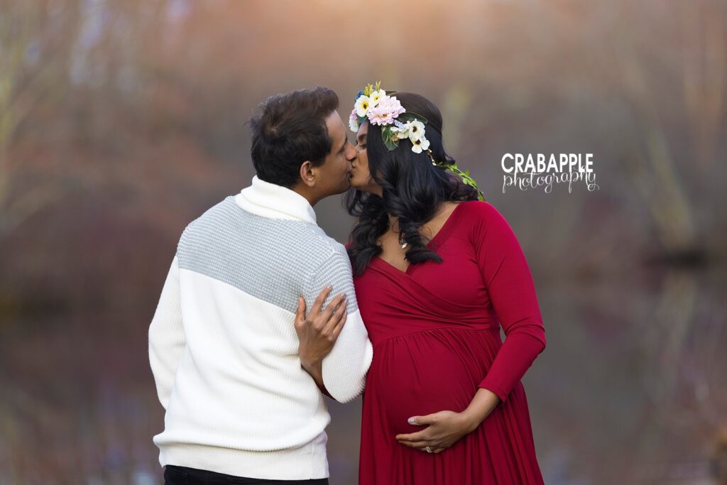 Romantic outdoor maternity photo with floral crown and partner kiss – Relaxed and Natural Maternity Photo Experience
