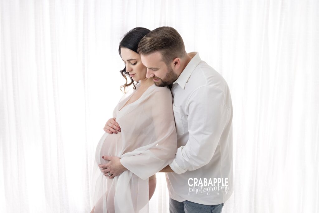 Elegant in-studio maternity photo with sheer fabric and gentle embrace – Professional Maternity Photography Andover MA