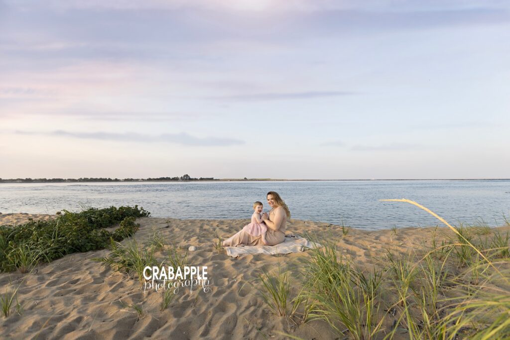 Sweet beach portrait of mother and daughter sitting on a blanket at Plum Island by a Boston area mommy and me photographer