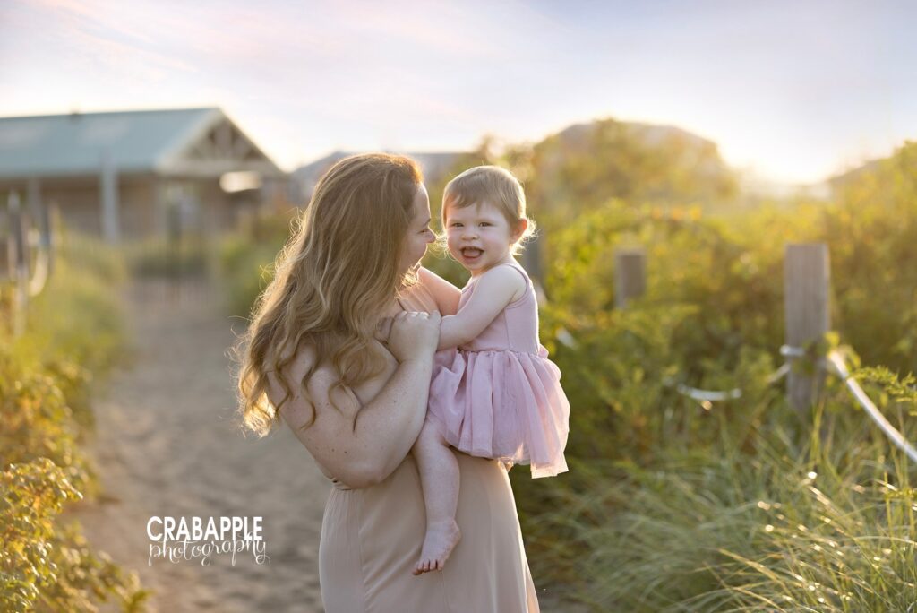 North Shore mom hugging daughter during a golden hour beach session near Newburyport
