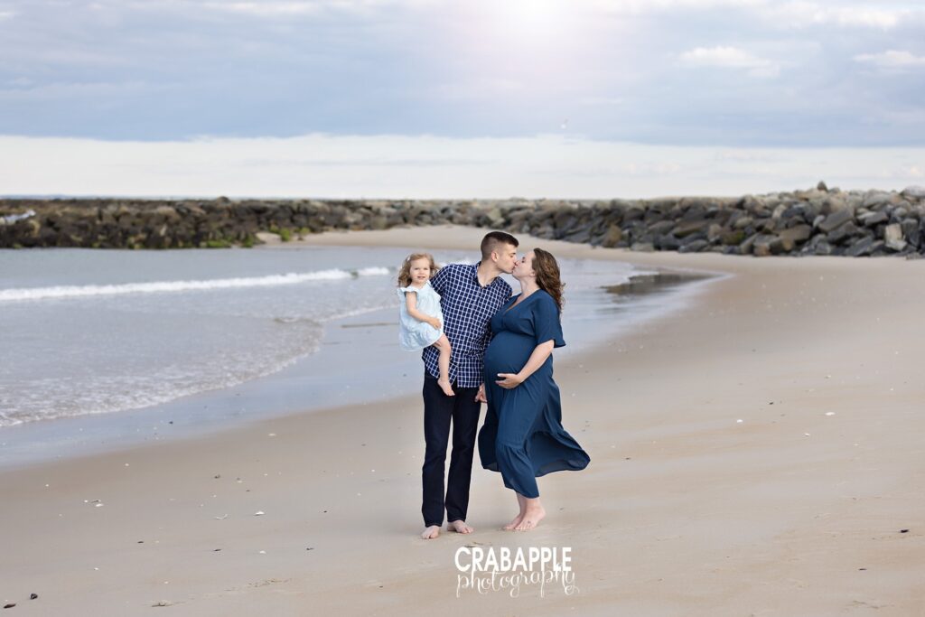 Coastal family maternity photos near Boston Family of three enjoying a joyful moment together during a beach maternity session near Boston.
